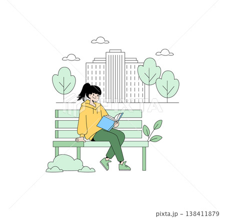 Girl sitting on a park bench reading a book with a relaxed expression. Urban setting with trees and buildings in the background, capturing a moment of leisure and enjoyment. 138411879