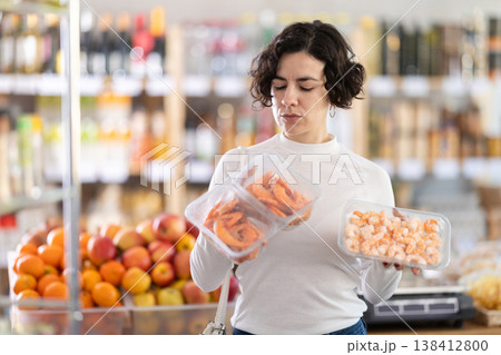 In store, woman near counter are looking at prawns In store, woman near counter are looking at prawns 138412800