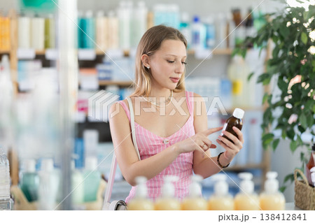 Woman choosing syrup at pharmacy Woman choosing syrup at pharmacy 138412841