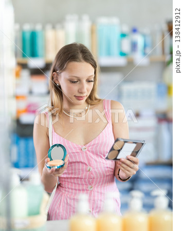 Woman in a dress choosing cosmetics in pharmacy 138412912