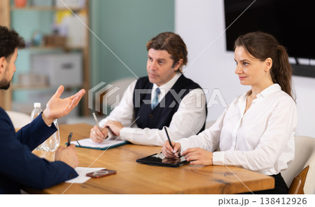 Business professionals discussing topic during corporate meeting at table Business professionals discussing topic during corporate meeting at table 138412926