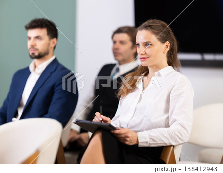 Lecture or meeting participants listen to speaker 138412943