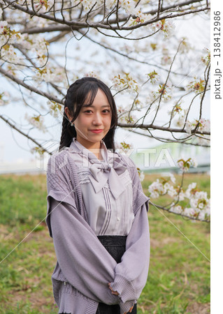 桜を背景に笑顔の若い女性のポートレート 138412986