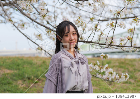 桜を背景に笑顔の若い女性のポートレート 138412987