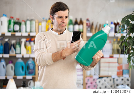 Man uses barcode to get information about liquid detergent in mobile application. 138413078