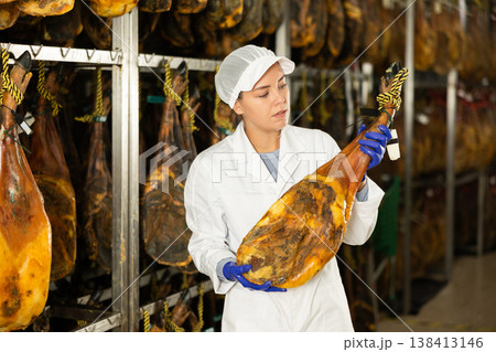 Girl employee checks jamon. Quality control 138413146
