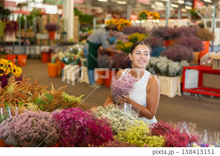 Young woman choosing bouquet of dried flowers 138413151