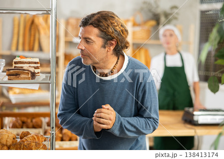 European man look at rack shelf showcase filled with various flour products European man look at rack shelf showcase filled with various flour products 138413174