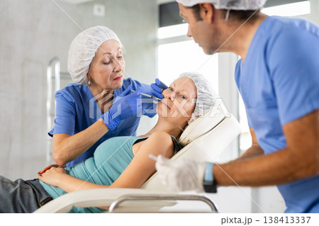Woman applying rejuvenating treatments by female doctor. 138413337