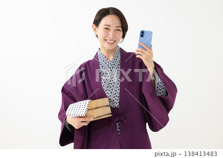 浴衣姿でスマホを持つ女性 138413483