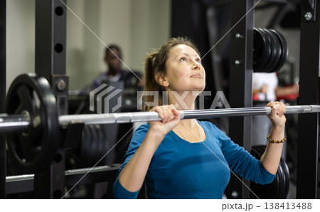 Sportswoman doing exercises with a barbell in gym 138413488