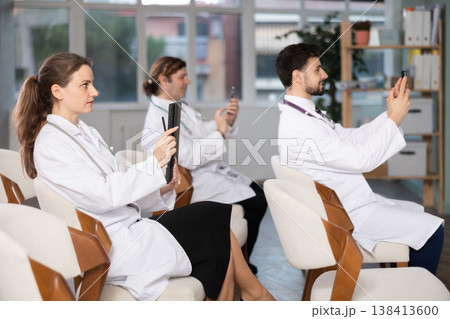 Medical students take pictures of information during meeting or lecture 138413600
