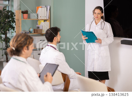 Female medical lecturer with folder addressed to attendees lecture 138413625