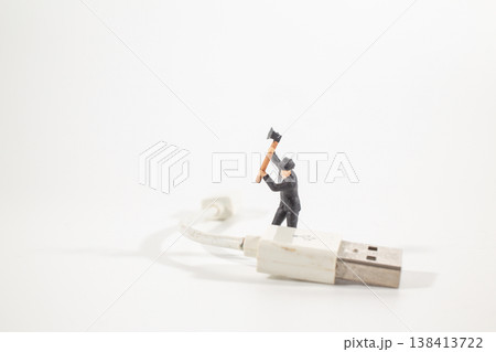 A Miniature worker striking worn charging cable 138413722