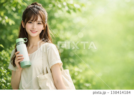 水筒を持つ笑顔の女性と自然の中の爽やかなライフスタイル 138414184