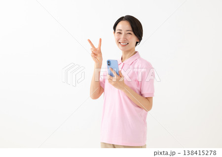 スマホを持ってピースする女性 138415278