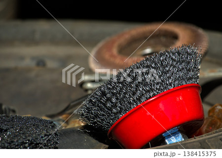 Close-up of a wire wheel brush and abrasive disc for metal cleaning 138415375