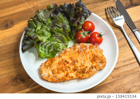 味噌漬けトンテキとサニーレタスとミニトマトのプレート料理 白い皿の家庭料理 138415534