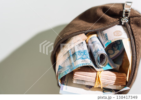 Open brown pouch with Kazakhstani tenge banknotes bundles, cash savings and financial security concept Open brown pouch with Kazakhstani tenge banknotes bundles, cash savings and financial security concept 138417349