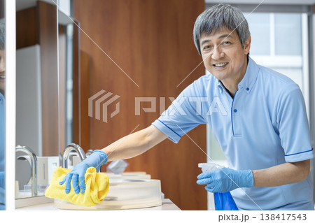 カメラ目線で笑顔のシニアの男性清掃スタッフ 138417543
