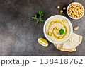 Traditional hummus with olive oil, chickpeas and pita bread on dark background. Top view. Copy space 138418762