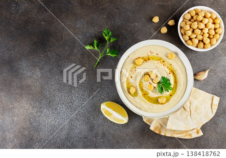 Traditional hummus with olive oil, chickpeas and pita bread on dark background. Top view. Copy space Traditional hummus with olive oil, chickpeas and pita bread on dark background. Top view. Copy space 138418762