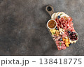 Charcuterie board with salami,cheese,crackers, olives jam nut on dark background.Top view.Copy space 138418775