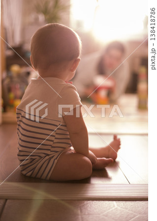 Child Radiates Warmth. Young Child Rests Calmly Surrounded By Gentle Glow. Young Child Peacefully Enjoying Warm Ambient Light While Seated Comfortably On Floor verical 138418786