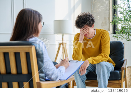 Young man talking to female professional psychologist counselor therapist 138419036