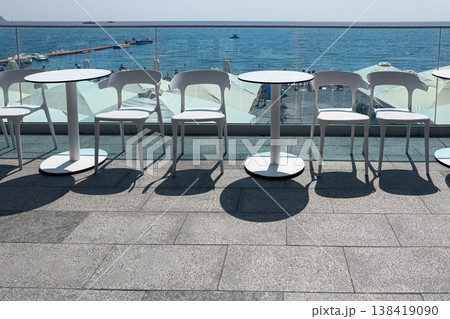 Chairs and tables near the water at noon Chairs and tables near the water at noon 138419090