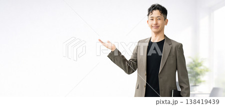 手のひらで案内をする男性ビジネスマン 手のひらで案内をする男性ビジネスマン 138419439