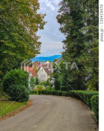 Charming street view in a European town with a traditional house covered in red ivy. 138419478