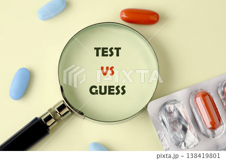 A magnifying glass focuses on TEST VS GUESS on a pale yellow surface A magnifying glass focuses on TEST VS GUESS on a pale yellow surface 138419801