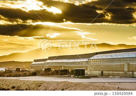 Sunset over greenhouses with mountains in the background in the evening. Industry agriculture in Spain 138420084