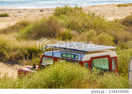 Solar panels on red vehicle parked in the countryside during daytime hours Solar panels on red vehicle parked in the countryside during daytime hours 138420088