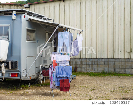 Clothes hang on a line near a recreational vehicle parked beside a building at a campsite Clothes hang on a line near a recreational vehicle parked beside a building at a campsite 138420537