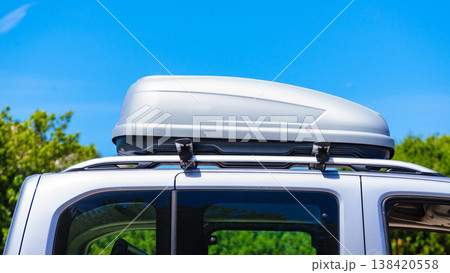 Silver roof box on a vehicle parked under blue sky. Travel, family vacation. Accessories for transportation. 138420558