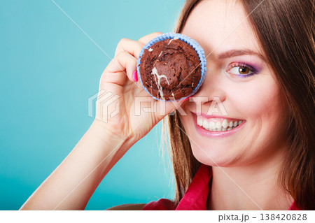 Funny woman holds cake in hand covering her eye 138420828