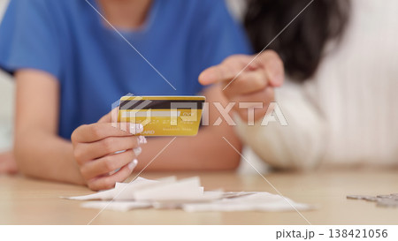 Holding credit card with receipts on table Holding credit card with receipts on table 138421056