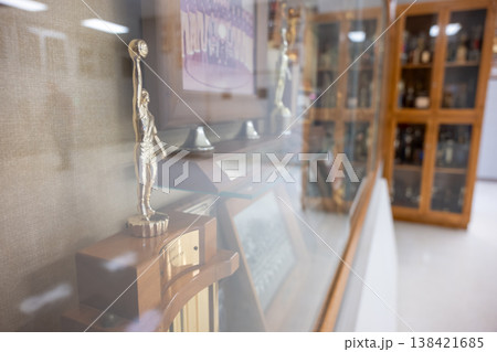 Trophy display showing sports achievements in a hall with glass cabinets for memorabilia Trophy display showing sports achievements in a hall with glass cabinets for memorabilia 138421685
