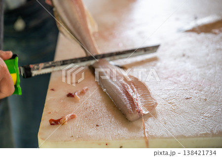 Filleting fish in a seafood market during the early morning hours in a coastal town Filleting fish in a seafood market during the early morning hours in a coastal town 138421734