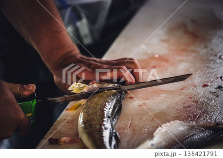 Hand holding an electric fillet knife to descale a walleye fish Hand holding an electric fillet knife to descale a walleye fish 138421791