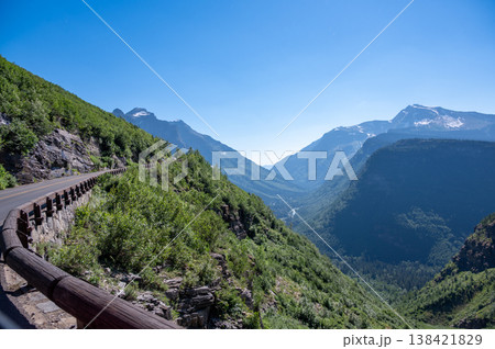 Scenic mountain drive showcases lush greenery and majestic peaks in the afternoon sunlight near Glacier National Park Scenic mountain drive showcases lush greenery and majestic peaks in the afternoon sunlight near Glacier National Park 138421829