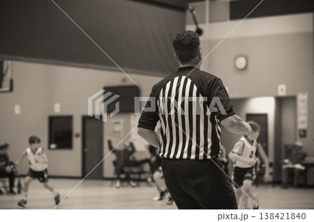 Referee makes a call during youth basketball game in indoor sports facility in the afternoon 138421840