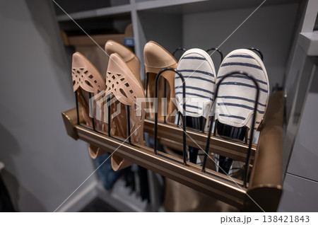 Shoe organizer with high heels and casual shoes on display in a modern closet setting during the daytime 138421843