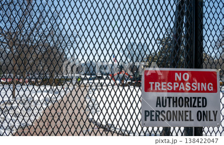 No trespassing sign displayed on a fence with snow coverage in the background at the United States White House in Washington DC 138422047
