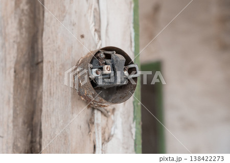 Rusty Old Doorbell Mounted on Weathered Wooden Wall Showing Vintage Electrical Components and Peeling Paint Texture in Muted Earth Tones with Green Trim Detail Rusty Old Doorbell Mounted on Weathered Wooden Wall Showing Vintage Electrical Components and Peeling Paint Texture in Muted Earth Tones with Green Trim Detail 138422273