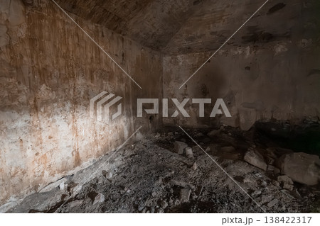 Abandoned Underground Concrete Bunker Interior With Peeling Walls, Debris Floor, Rust Stains, Dim Lighting And Decay Textures In Earthy Tones 138422317