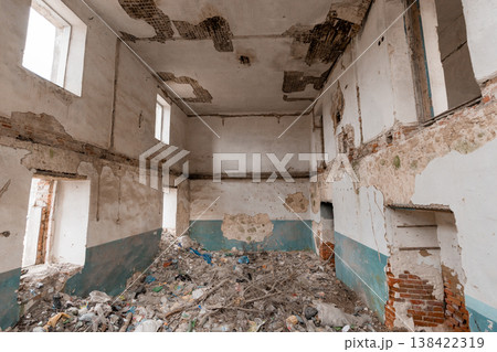 Dilapidated Abandoned Building Interior With Peeling Paint, Exposed Brick Walls, Debris Littered Floor, Cracked Ceiling And Faded Blue Trim In Derelict State Showing Decay And Neglect 138422319
