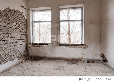 Dilapidated Room With Broken Windows Showing Bare Trees Outside Amidst Peeling White Walls And Exposed Wooden Lattice On Left Side In Abandoned Building Interior Scene 138422358
